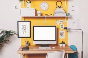 Modern creative workspace on yellow wall.